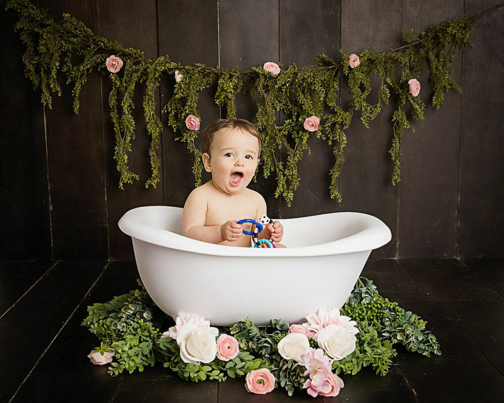 One-year-old girl, sitting in white tub for her in studio, pink, first birthday session in Ocean city, New Jersey.