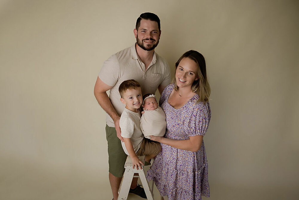 Cute family portrait ideas of all wife and husband and their toddler son and newborn baby girl for their lavender maternity and newborn session in Cherry Hill, New Jersey.