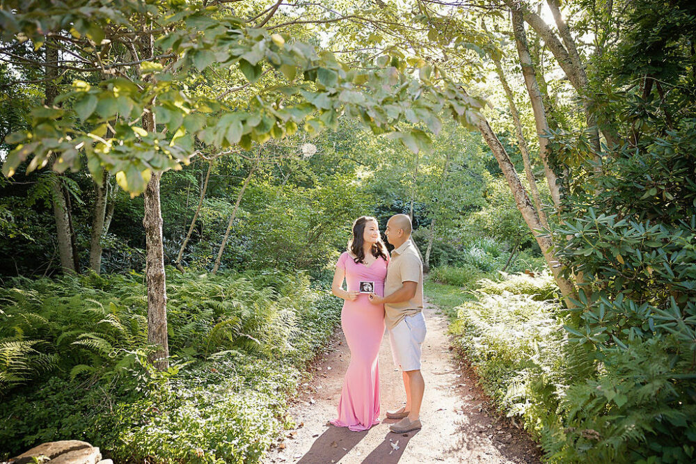 Couple maternity photo of husband and wife holding ultrasound photo and garden trail for their Mylestone maternity and newborn session in Lumberton, New Jersey.