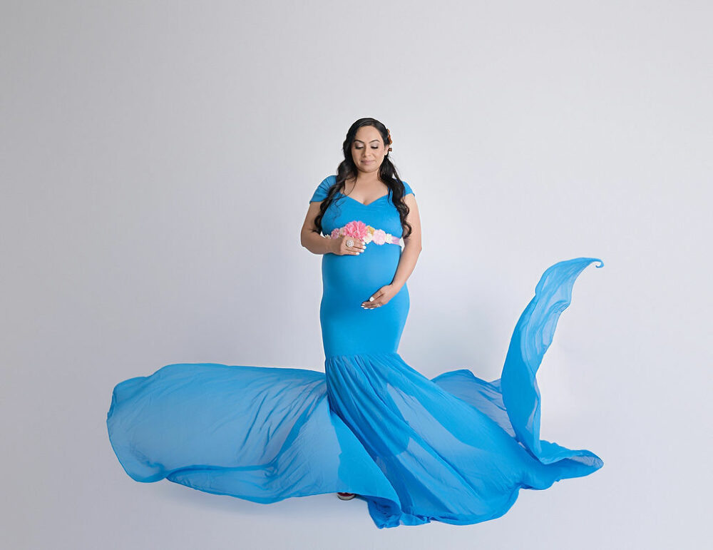 Woman holding her belly wearing maternity dress and posing for her maternity photoshoot Taken in Mount Holly, New Jersey.