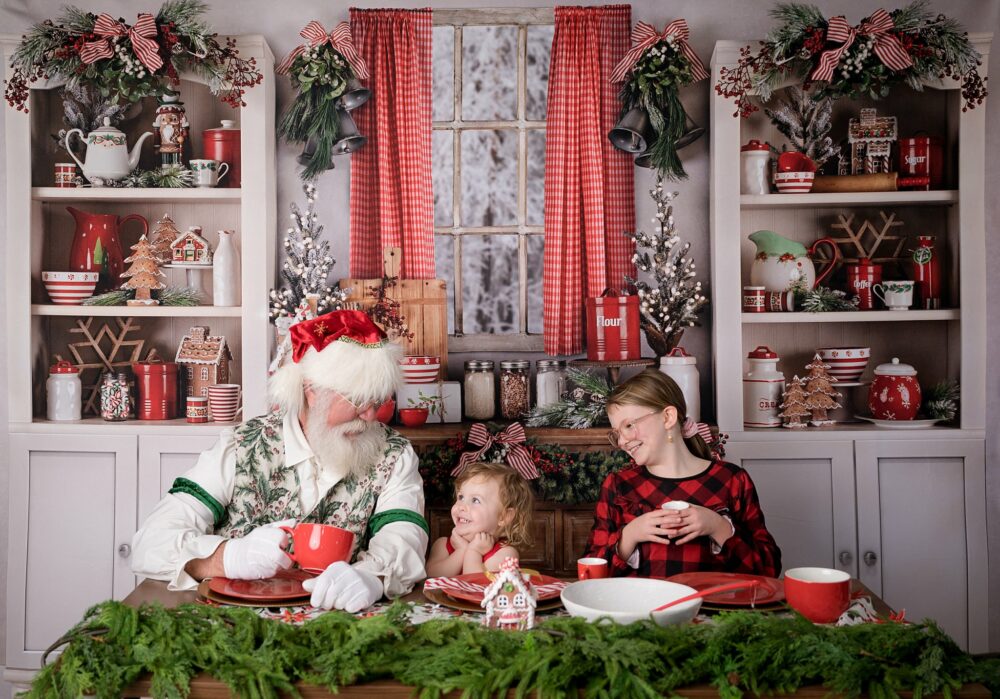 Santa smiling at a little girl in the kitchen while sipping hot cocoa
