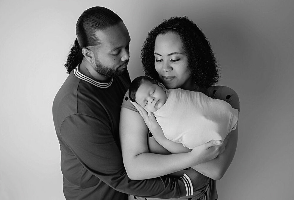 Black-and-white photo of a man and a woman posing for their family photography taken during their in studio, maternity session, and Moorestown, New Jersey.