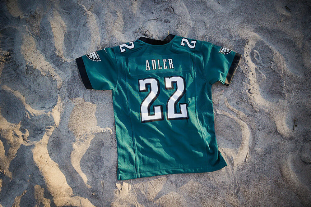 An Eagles jersey face down on sand for a beach maternity session in Ocean city, New Jersey.