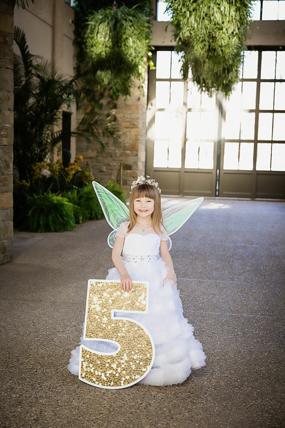 Baby mama song, photos of a girl dressed as a fairy, holding a large number five for her fairy garden first birthday session in Camden, New Jersey.