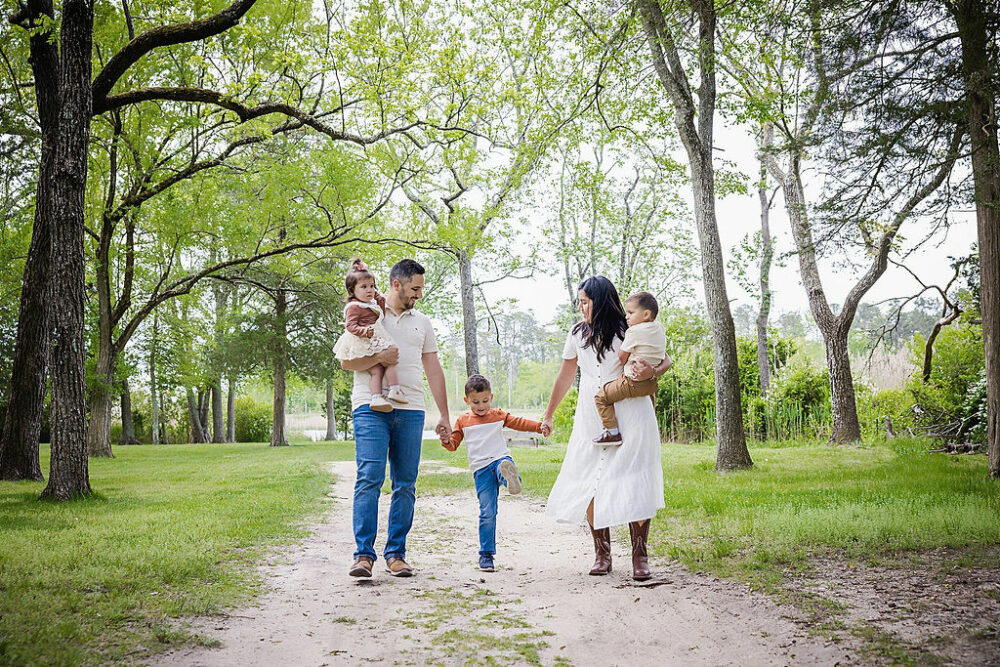 A family portrait of a woman and man with their three kids on a trail for a Spring Outdoor Family Session in Southampton, New Jersey.