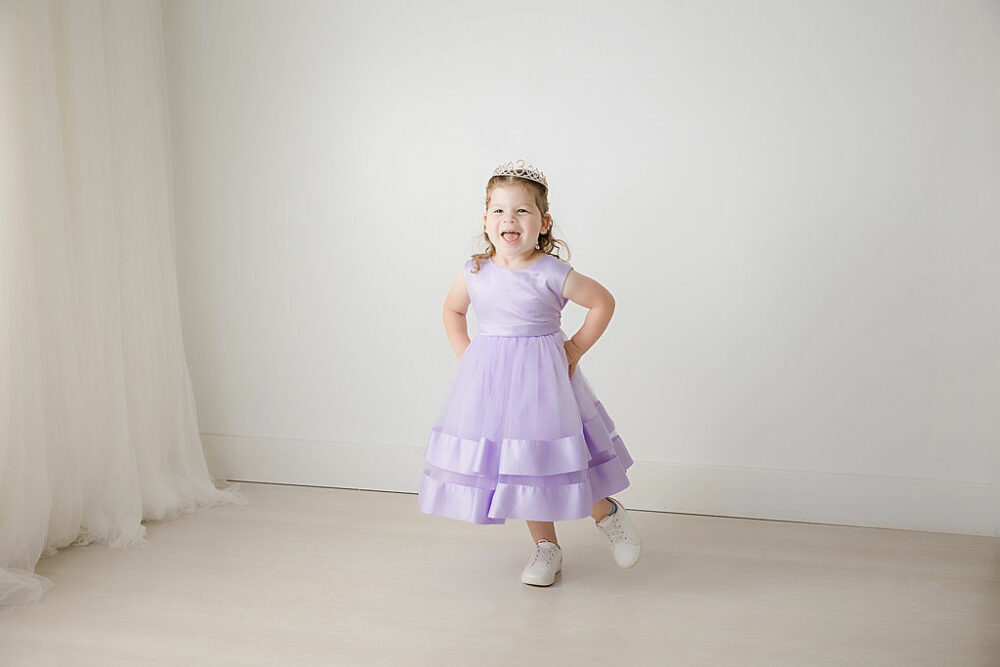 A lifestyle photo of a girl wearing cute sleeveless dress and tiara for her birthday photography session in Cherry Hill, New Jersey.