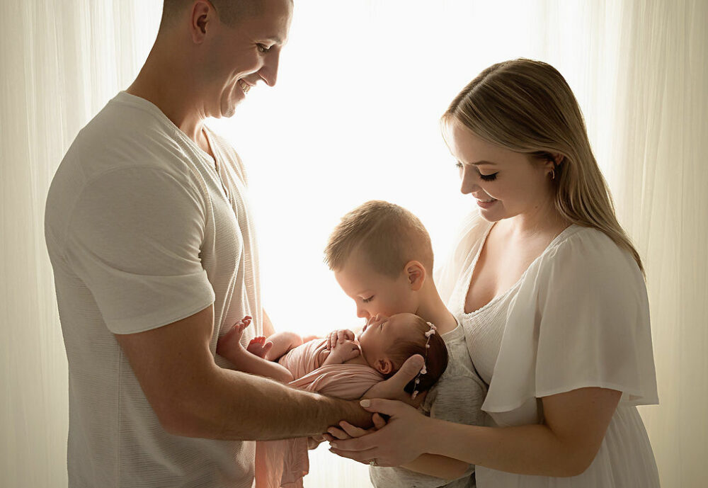 A close-up of a family facing each other and smiling down at their daughter and son posing for their baby photography session in westampton, New Jersey.