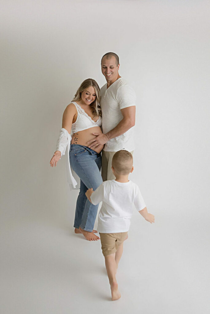 A family photo of a couple and their toddler son posing and having fun during their maternity session in Deptford, New Jersey.