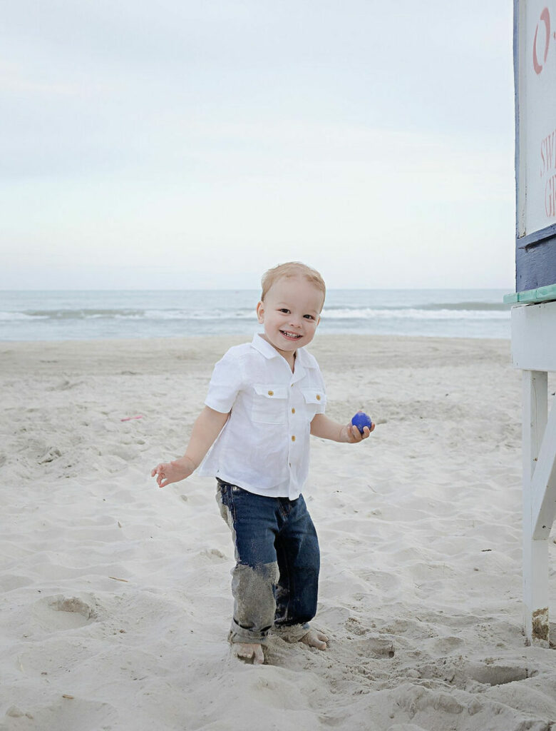 A lifestyle portrait of a boy playing in the sand for his summer beach family session in toms River, New Jersey.