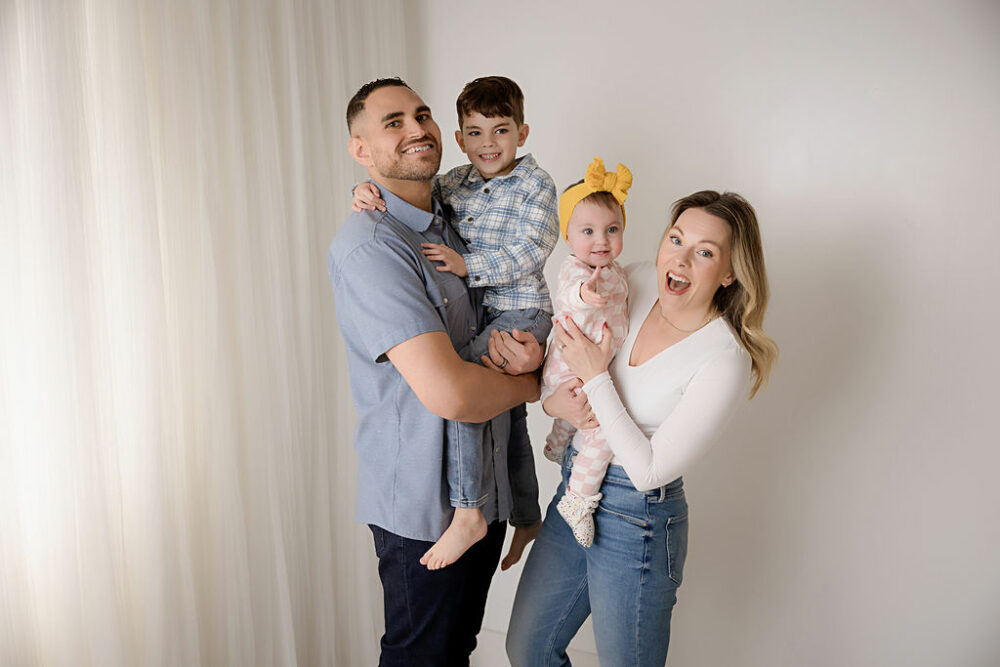 A family photo of a couple and their two kids having fun during their daughter's first birthday portrait photography session in Southampton, New Jersey.