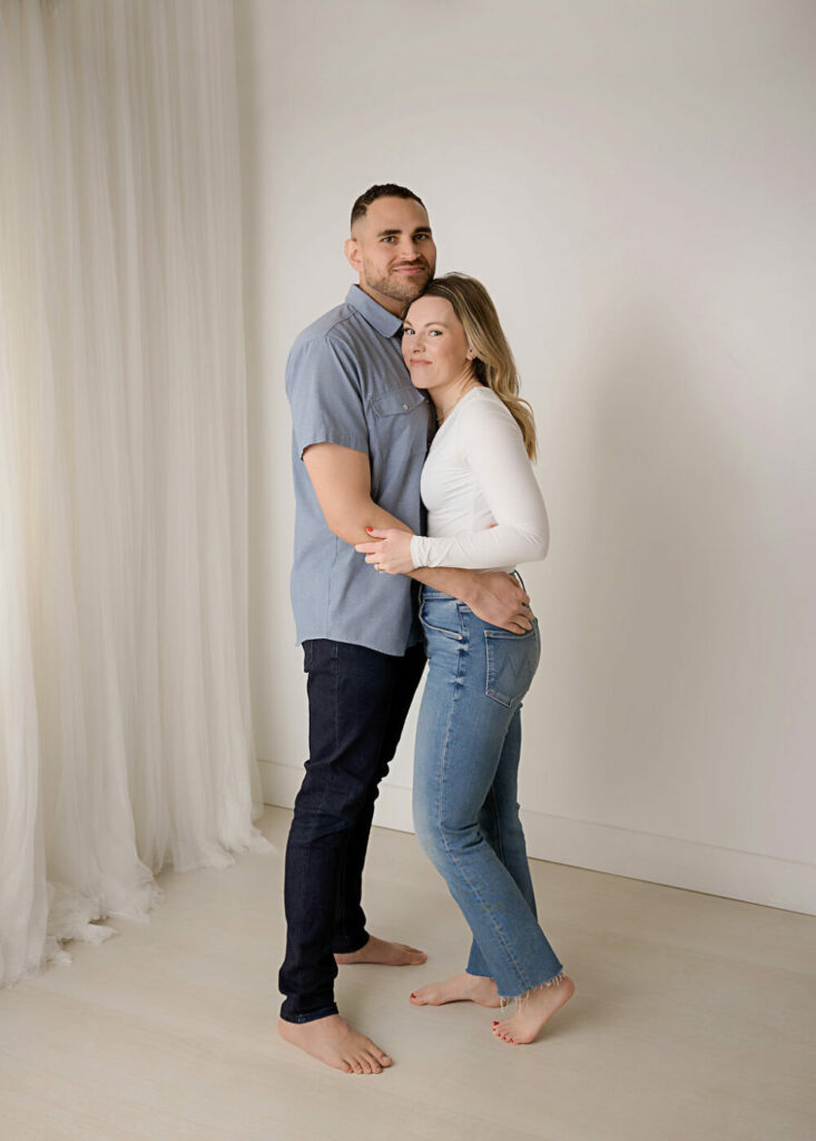 A beautiful portrait of a man and woman holding each other close as they lightly pose for their picture in professional studio in Eastampton, New Jersey.