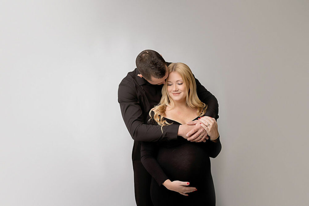 A beautiful portrait of a couple holding each other and hugging during a formal maternity session in Southampton, New Jersey.